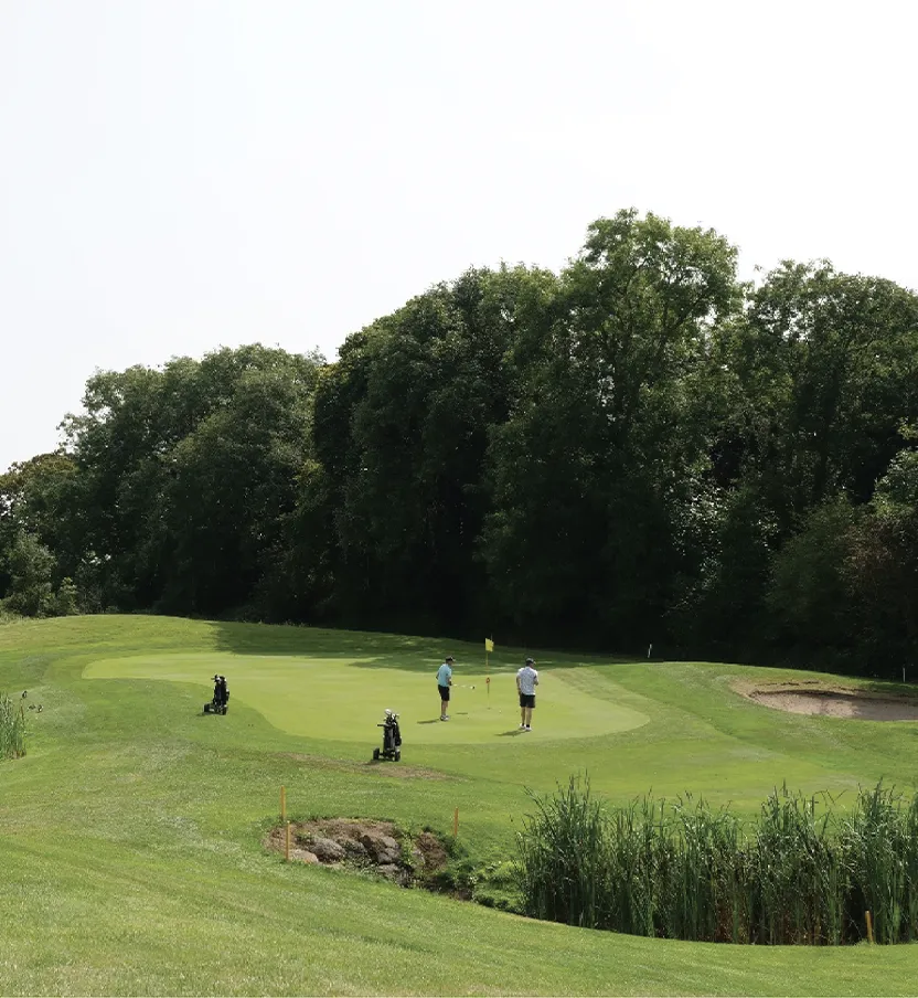Two people putting on the putting green